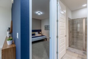 A bedroom with a bed, bedside table, and a potted plant. - Amazing 5br House w/ Pool & Perfect Location! (Kissimmee)