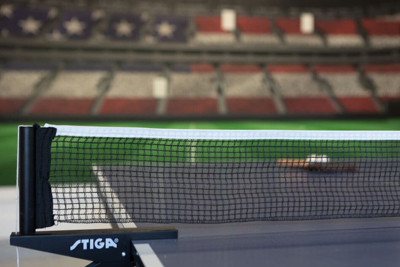 Un court de tennis avec un filet et un logo sur le poteau du filet.
