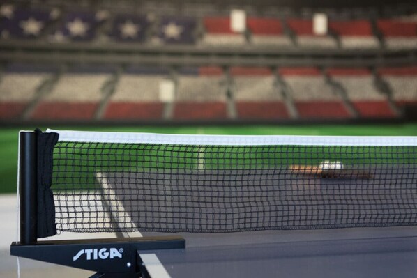 A tennis court with a net and a logo on the net post.