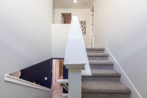 A staircase with a white handrail leading to a landing. - Amazing 5br House w/ Pool & Perfect Location! (Kissimmee)