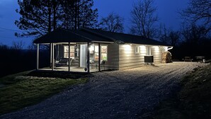 Une petite maison de plain-pied, dotée d’un porche et d’une allée gravillonnée.