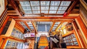 A room with a sloped ceiling, wooden beams, and a central staircase. - Alpaca Treehouse in the Bamboo Forest (Atlanta)
