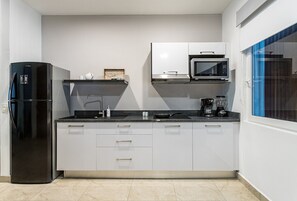 Enjoy cooking in this kitchen with a refrigerator, microwave, and coffee maker, plus ample counter space and a large window.