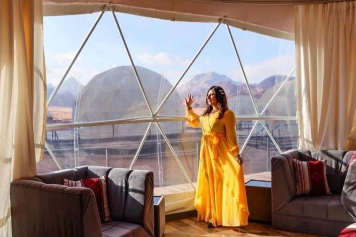 Una habitación con un ventanal grande, dos sofás y una persona vestida de amarillo.
