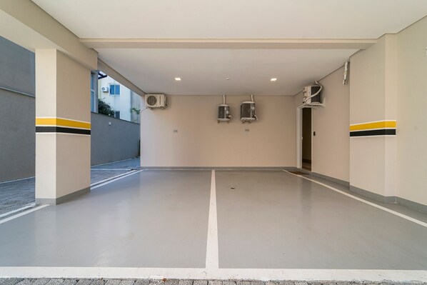 Um espaço interior limpo e vazio, com piso plano, paredes bege e duas unidades de ar condicionado fixadas na parede.