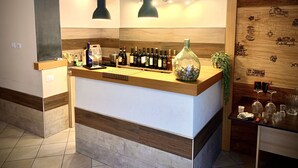 A bar area with a wooden counter, wine bottles, glasses, and a decorative bottle of corks. - Cinema Open-space (Catania)