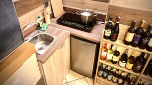 A modern kitchen with a built-in dishwasher, a stovetop, and a wine rack. - Cinema Open-space (Catania)