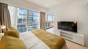 A modern hotel room with a large bed, a flat-screen TV, and a balcony with a city view. - La Vie Suite Madero (Buenos Aires)