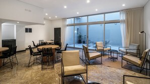 A spacious conference room with a large table and chairs, large windows with curtains, and a modern ceiling design. - La Vie Suite Madero (Buenos Aires)