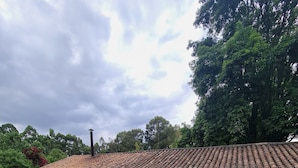A white building with a tiled roof and a stone pathway leading to a covered patio area. - Hacienda Suescun  (Tibasosa)