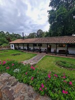 A white building with a tiled roof and a stone pathway leading to a covered patio area.