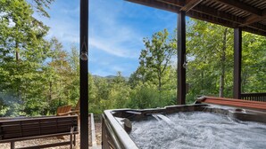 A hot tub with a wooden bench and chairs, surrounded by a wooden pergola, set in a lush green forest. - The Sanctuary in Blue, Long Range Mountain Views (Blue Ridge)
