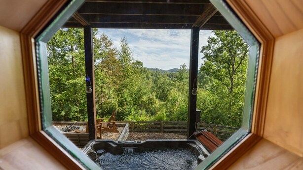 A hot tub in a hexagonal wooden structure with a view of a forested area. - The Sanctuary in Blue, Long Range Mountain Views (Blue Ridge)