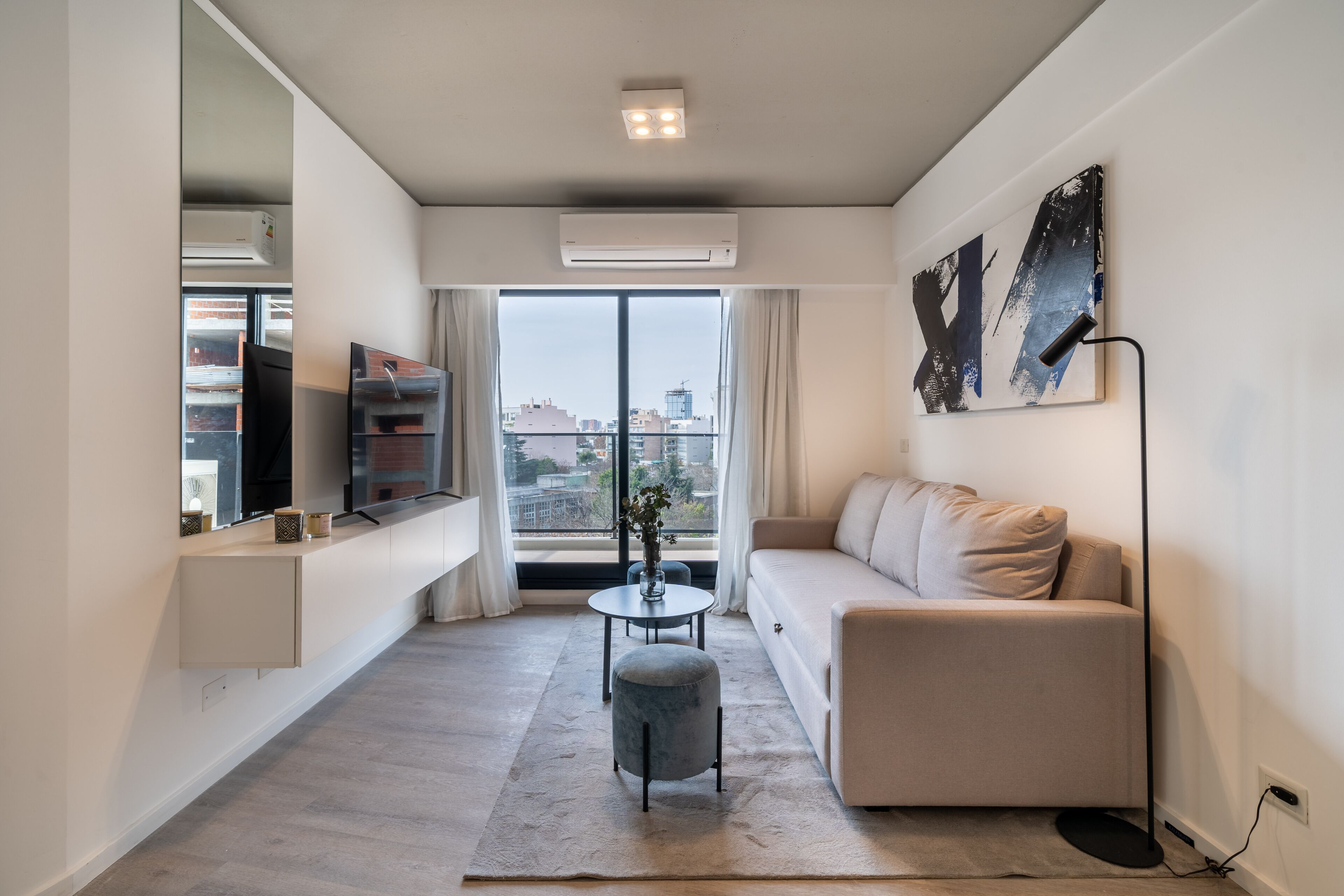 Een moderne woonkamer met een bank, een bijzettafeltje en een televisie.