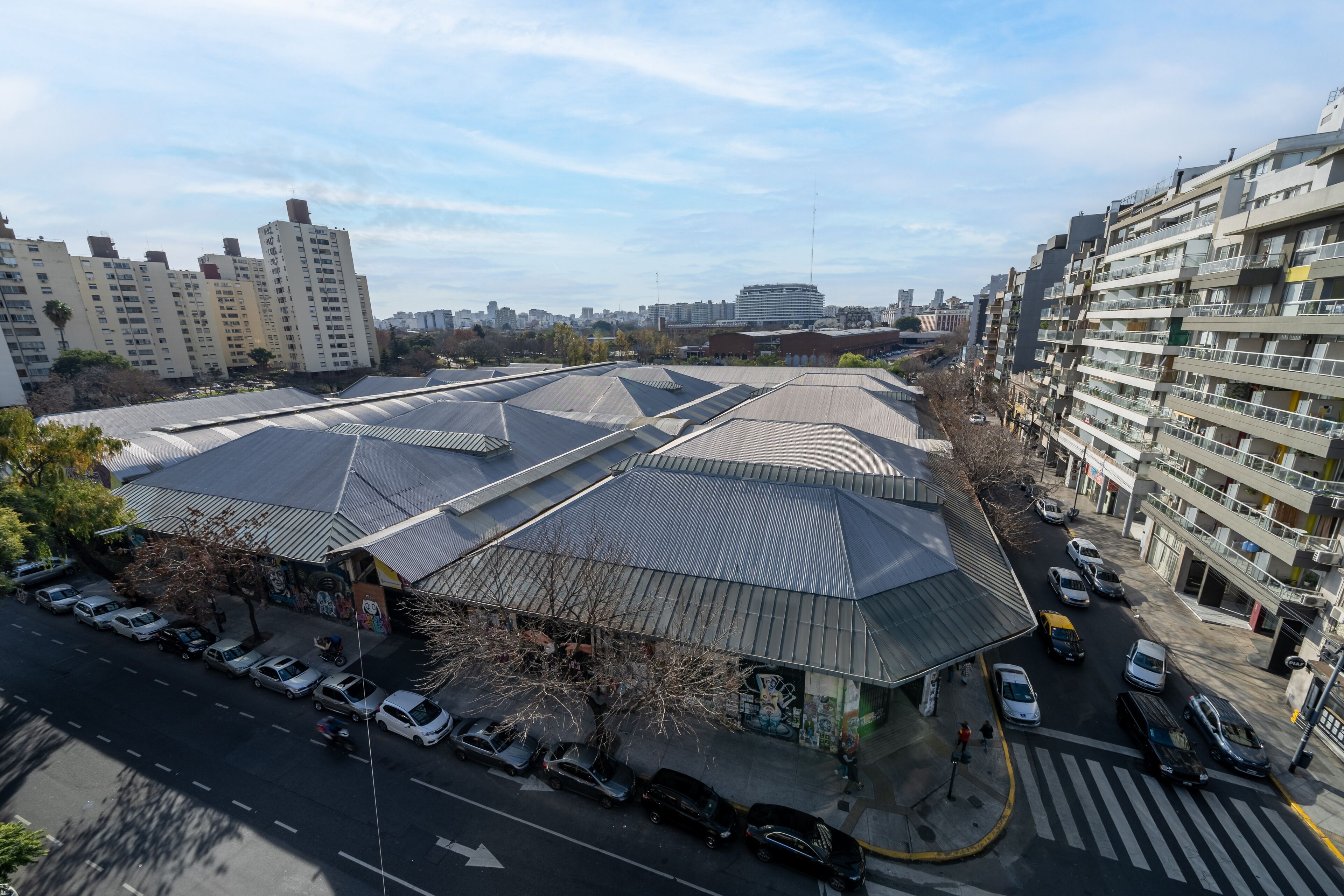 A multi-story parking garage with a modern design, surrounded by residential buildings and a clear sky.