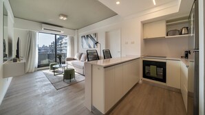 Une cuisine moderne dotée d’un îlot central, d’un four encastré et d’un coin repas avec un canapé et des chaises.