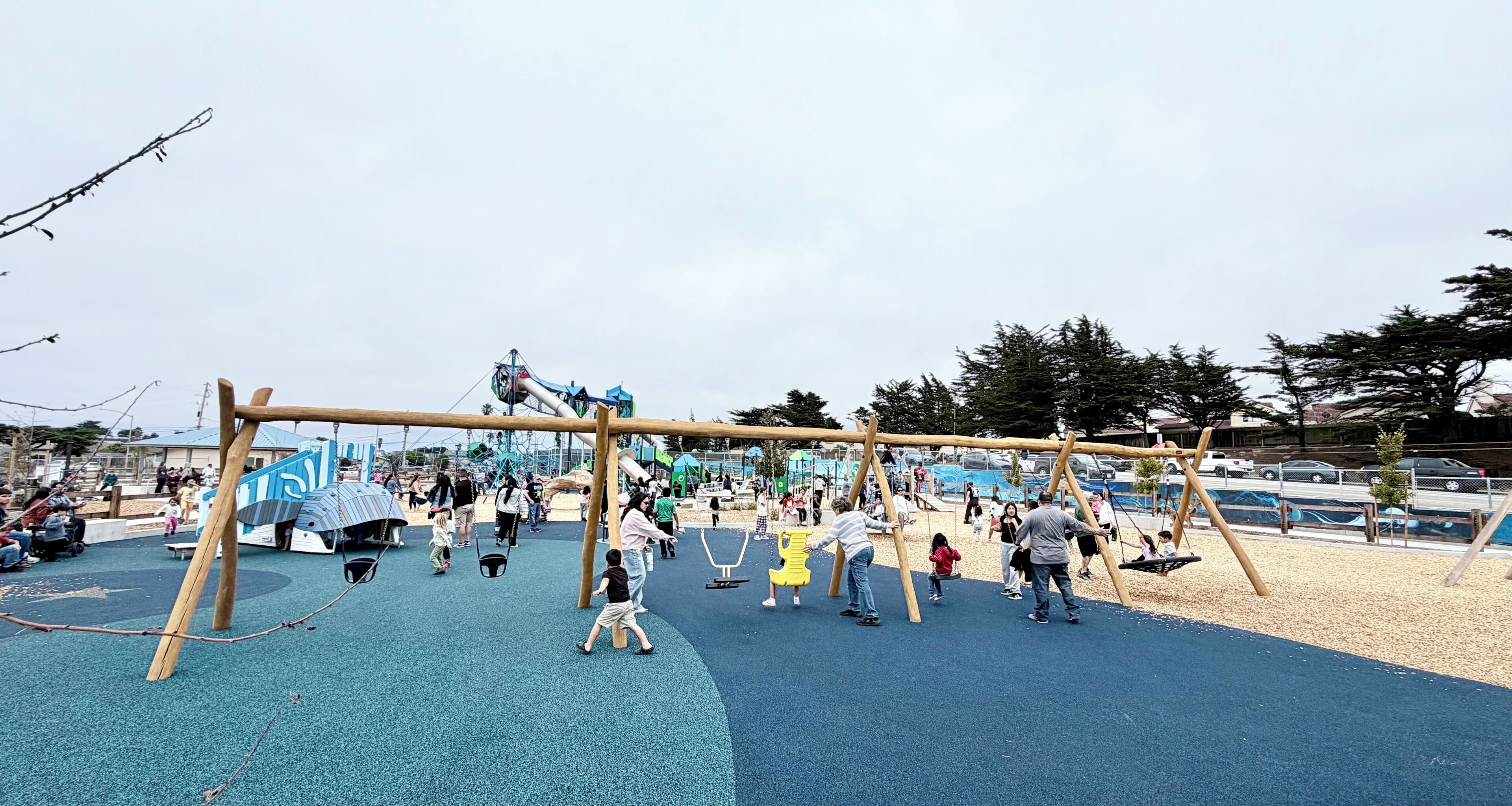Un parque infantil con columpios, tobogán y estructura para escalar.