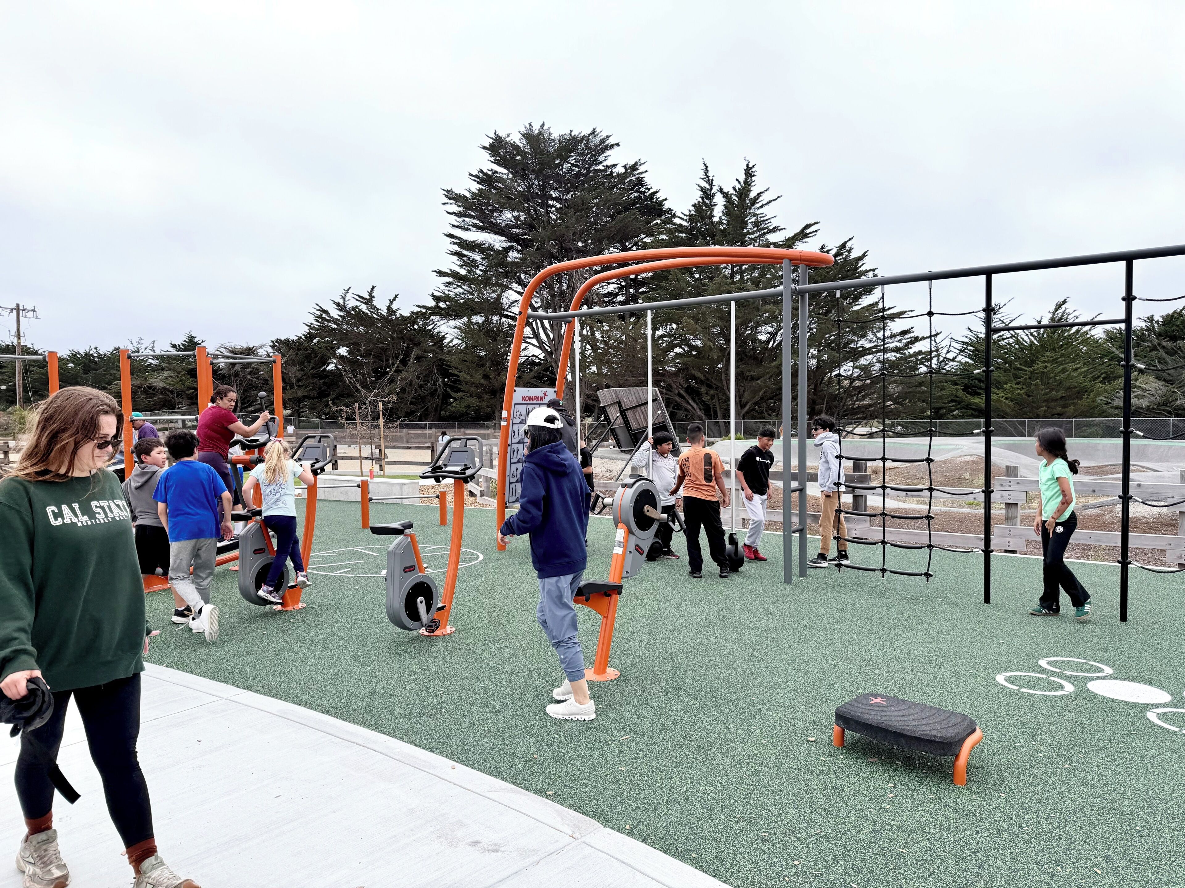 Ein Außenbereich mit Fitnessgeräten und einem Spielplatz.