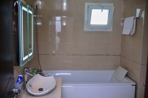 A bathroom with a white sink, a mirror, a window, and a towel rack. - Guided Hospitality (Lagos)