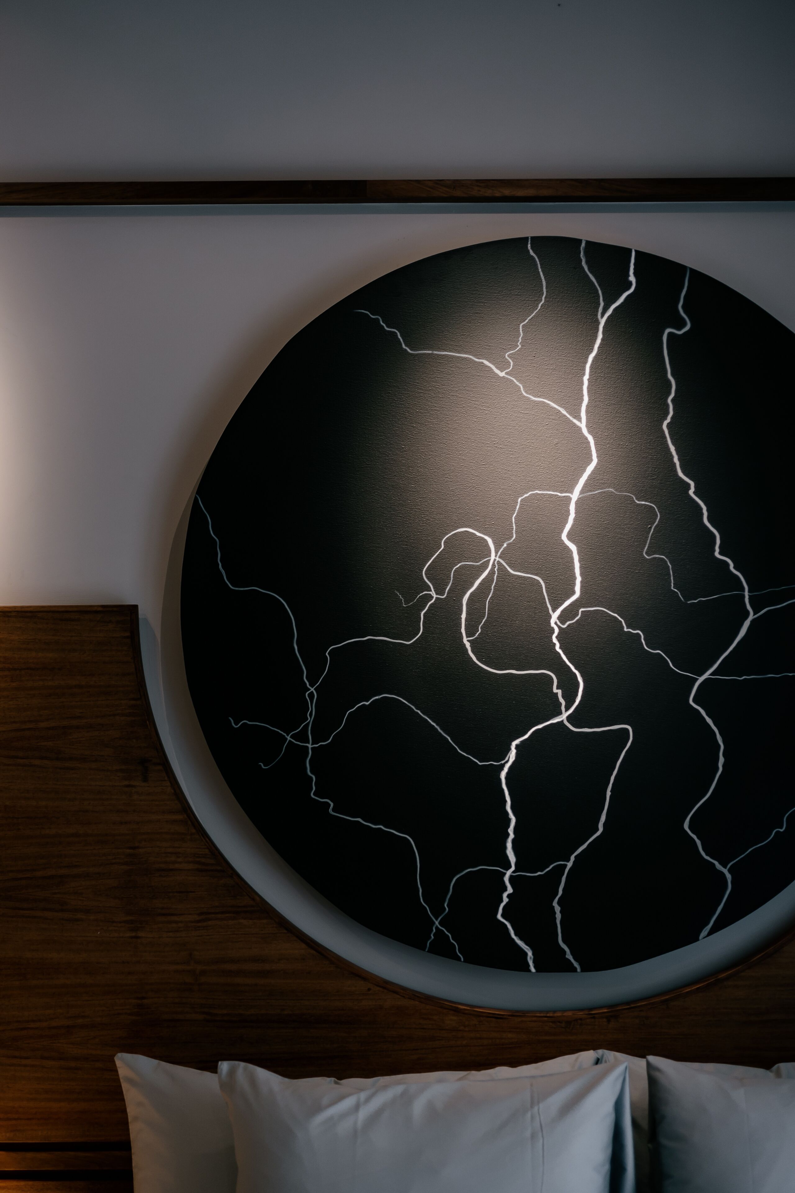 A round wall art with a black background and white lightning patterns.