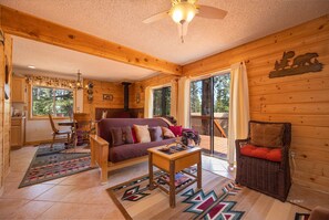 Cozy cabin interior with a seating area, dining table, and wicker basket.