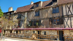 Experience the charm of a traditional European building with exposed beams and a stone facade, home to the LE DIVIN BAR A VIN.