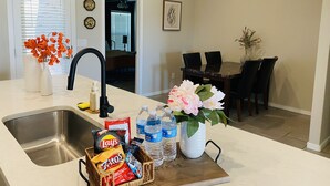 A kitchen with a sink, a dining area with a table and chairs, and a hallway leading to another room. - Cozy home # Safe Neighborhood & Pet Friendly (Lubbock)
