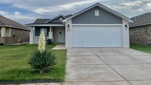 A residential house with a garage, a well-maintained lawn, and a clear sky. - Cozy home # Safe Neighborhood & Pet Friendly (Lubbock)