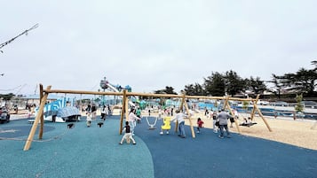 A playground with swings, a slide, and a climbing structure.