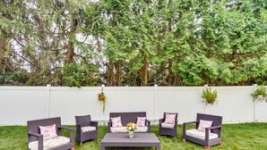 An outdoor seating area with wicker furniture and a central table, surrounded by a white fence and trees. - Cozy Albany Vacation Rental ~ 5 Mi to Downtown! (Albany)