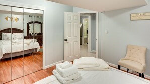 A bedroom with a bed, a chair, a mirror, and a door leading to another room. - Cozy Albany Vacation Rental ~ 5 Mi to Downtown! (Albany)