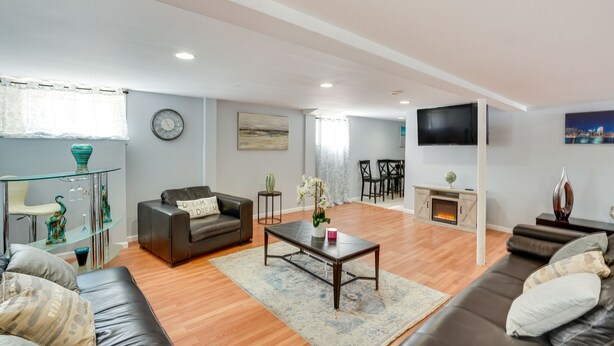A modern living room with a leather sofa, a glass coffee table, and a fireplace. - Cozy Albany Vacation Rental ~ 5 Mi to Downtown! (Albany)