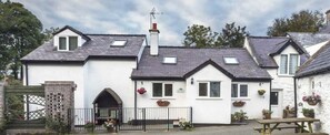 Traditional building with a central entrance, flanked by windows and flower boxes, offering a charming and serene atmosphere.