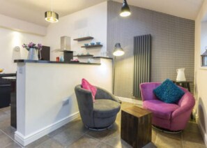 Cozy living space with a counter, armchair, and sofa.