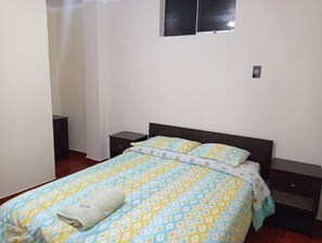 Cozy retreat with a single bed, bedside tables, and a small window.