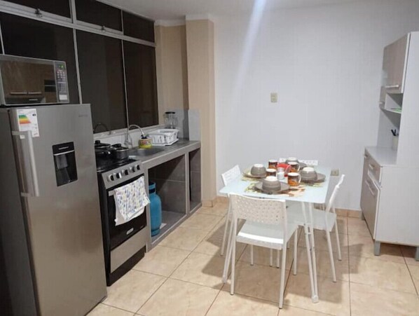 Compact kitchen with modern appliances and dining area, perfect for small living spaces.