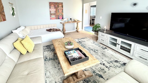 A living room with a sofa, coffee table, TV, and artwork on the wall. - The Ultimate Gateway, near Monterey, Carmel, Pebble Beach, Big Sur- STR25-000022 (Marina)