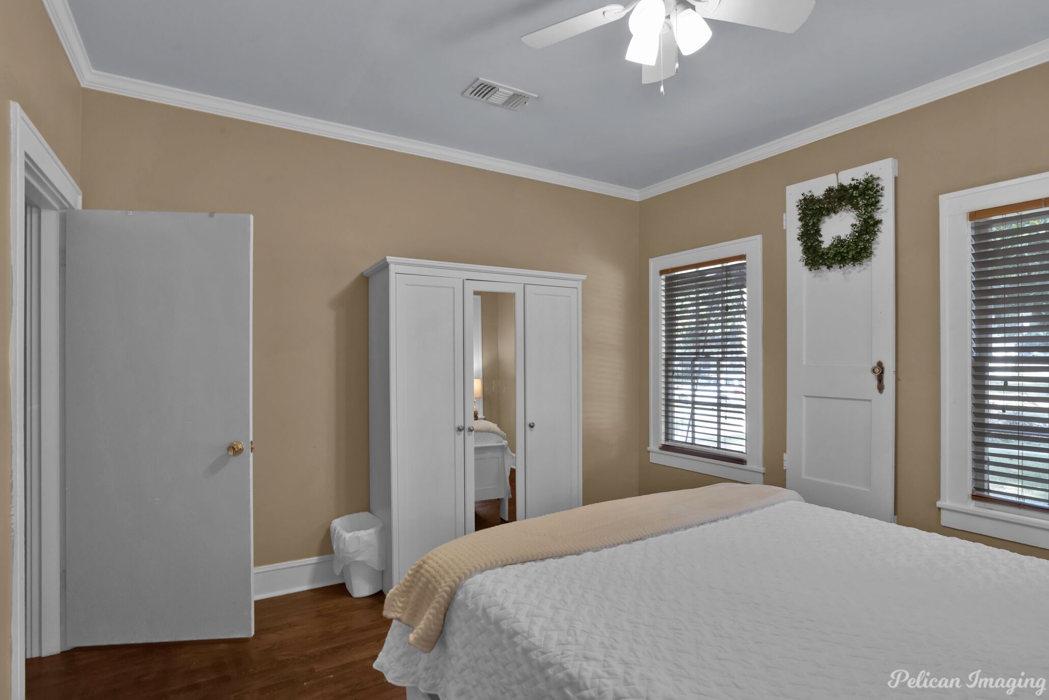 Un dormitorio con cama, armario y puerta decorada con un adorno circular.