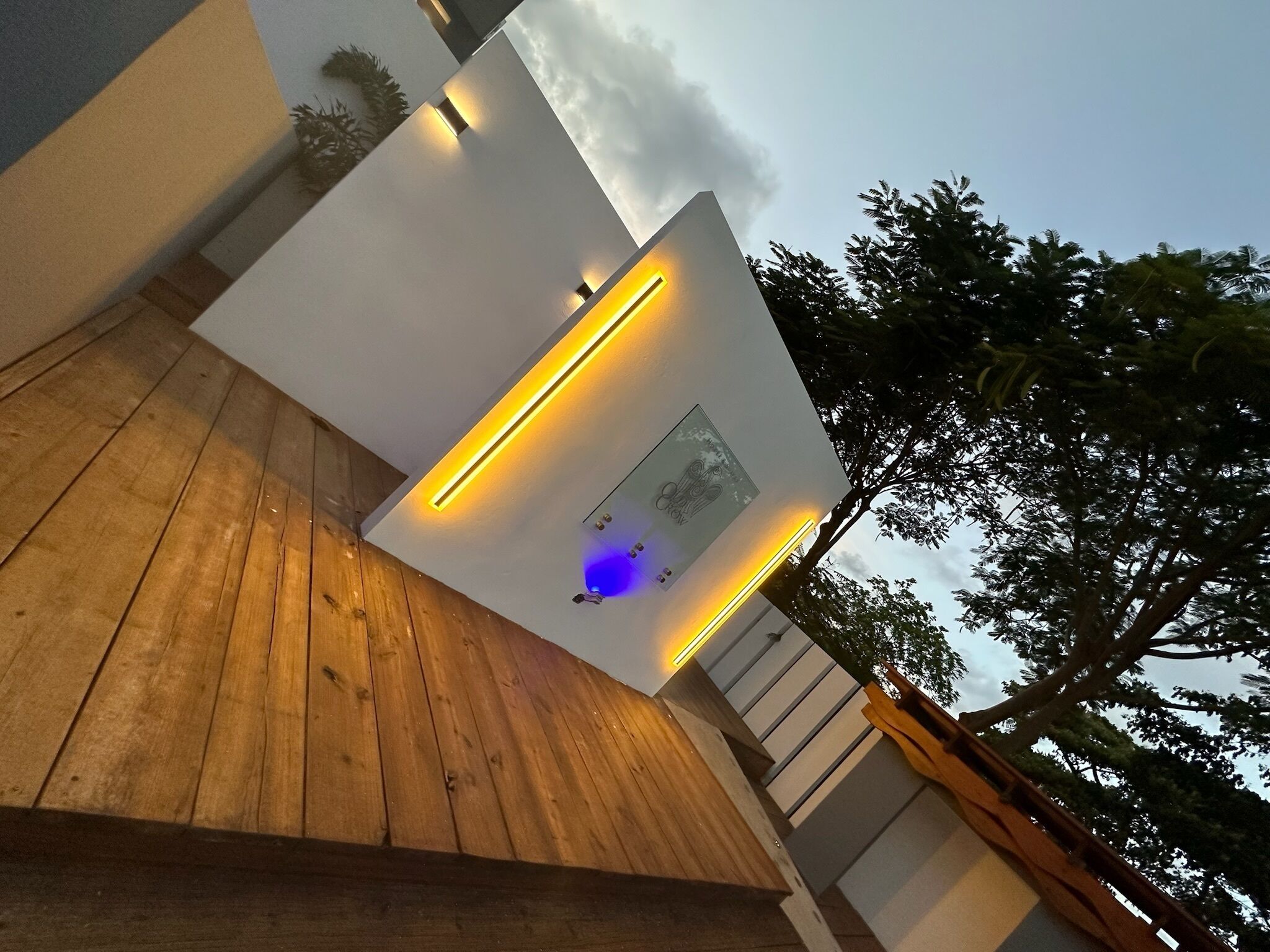 A modern building with a wooden deck and a wall-mounted light fixture.