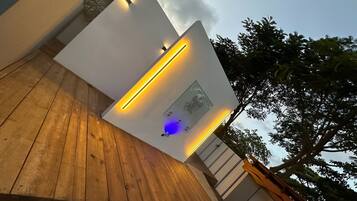 A modern building with a wooden deck and a wall-mounted light fixture.
