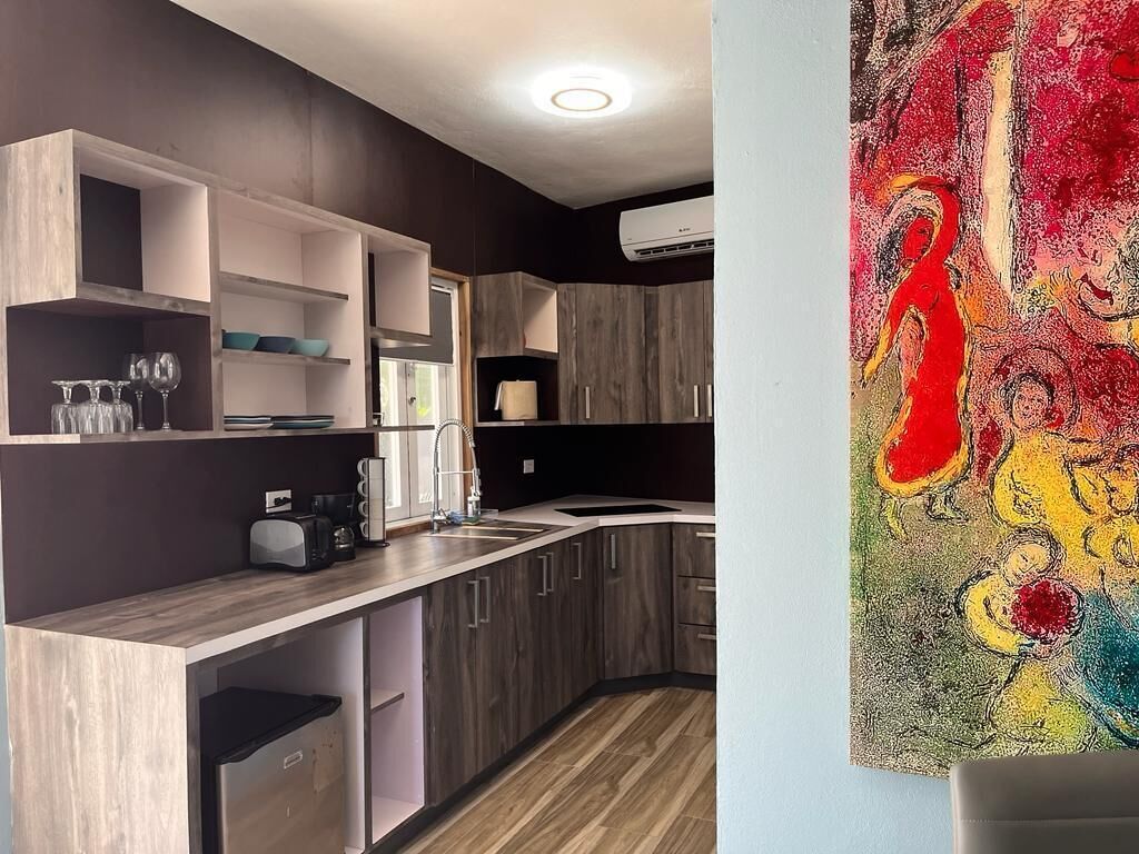 A modern kitchen with wooden cabinets, a built-in sink, and a countertop with a coffee maker.