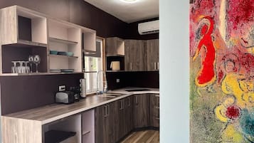 Una cocina moderna con armarios de madera, un lavamanos integrado y una encimera con una cafetera.