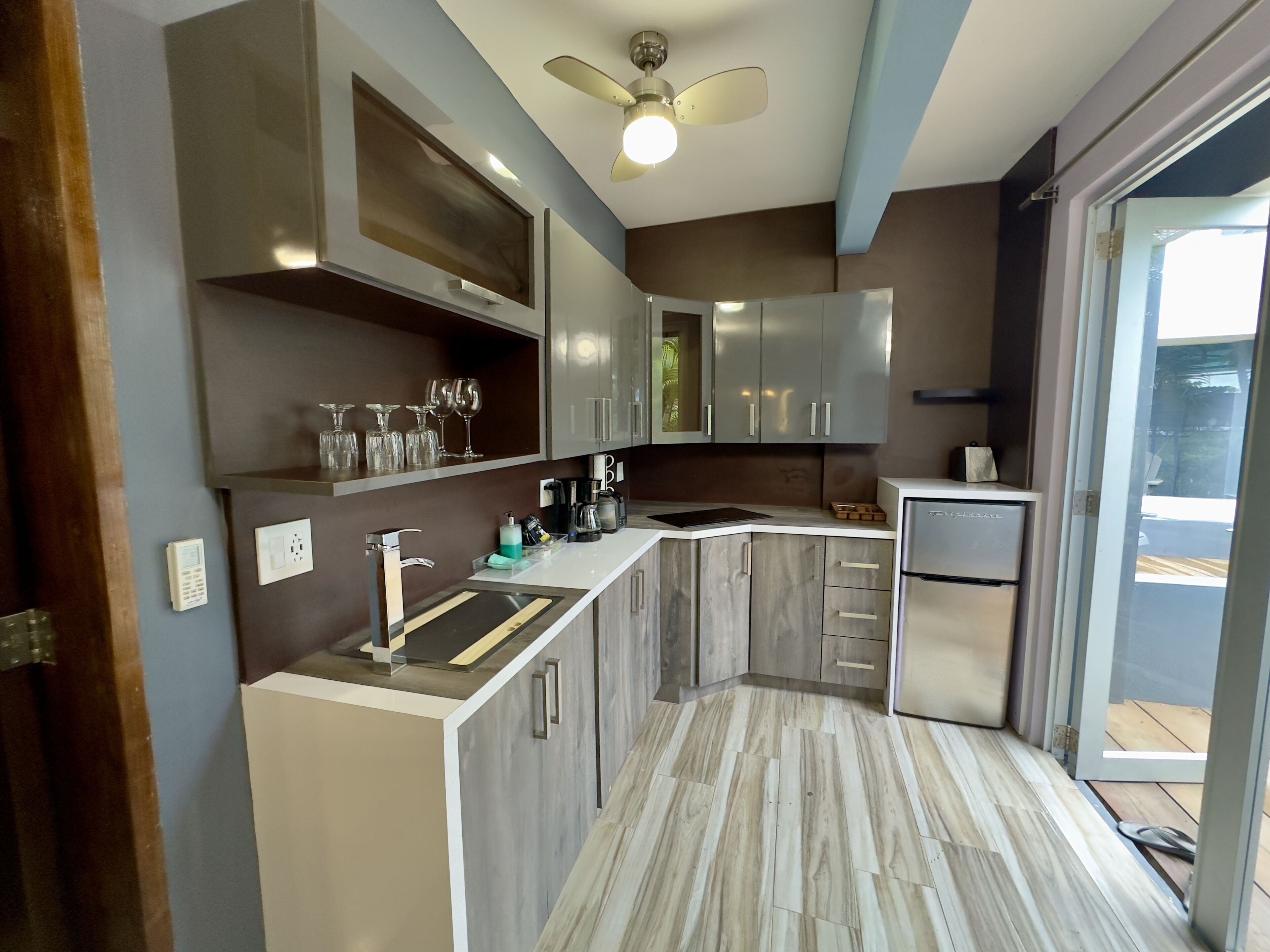 A modern kitchen with a built-in oven, a refrigerator, and a countertop with a sink.