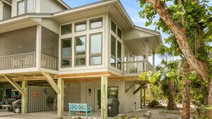 A multi-story building with a covered porch, a garage, and a patio area.