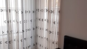 A bedroom with a bed, a ceiling fan, and sheer curtains with a butterfly pattern. - Beautiful 6Bedroom 6Bath Apartment- Colombia  (Girardot)