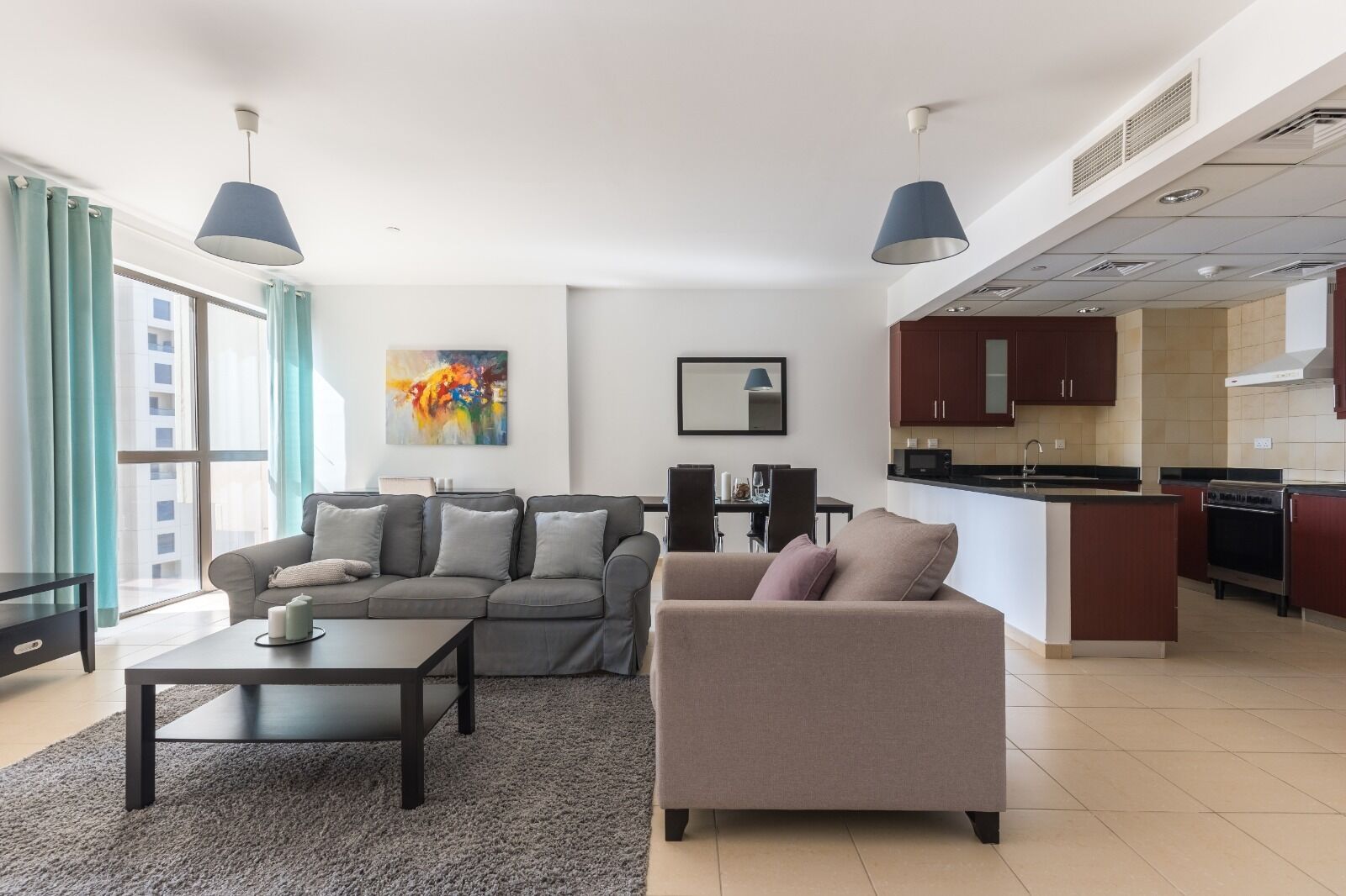 A modern living room with a sofa, a coffee table, and a dining area.