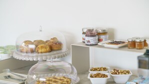 Un bufé con diversos pasteles, frutos secos y condimentos.