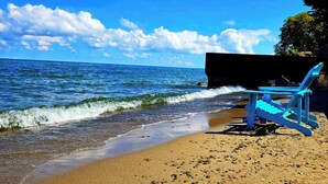 Une plage avec une chaise et une formation rocheuse en arrière-plan.