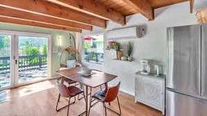 A modern kitchen with a wooden ceiling, a stainless steel refrigerator, and a dining area with a table and chairs. - Lakeside Retreat: Newly Renovated Home with lake views and Hot tub (Groveland)