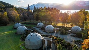 A series of geodesic dome structures in a natural setting with a mountainous backdrop. - Cross Hill Glamping (Lake Hawea)